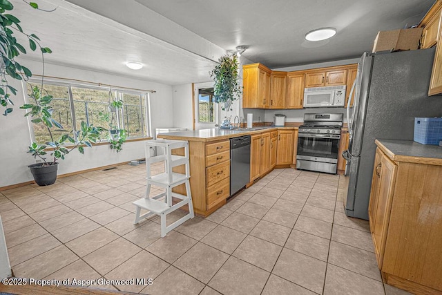 5904 County Road 31, Craig, CO 81625 - kitchen featuring stainless steel appliances, light tile patterned floors, a peninsula, and a sink