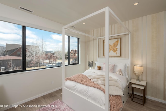 bedroom with recessed lighting, visible vents, baseboards, and wood finished floors