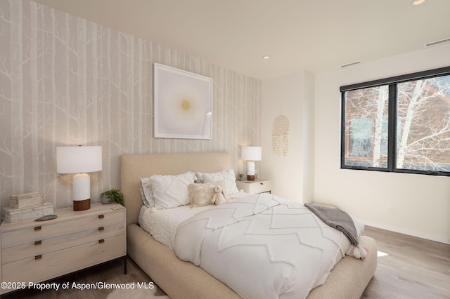 bedroom featuring visible vents, wallpapered walls, baseboards, recessed lighting, and wood finished floors