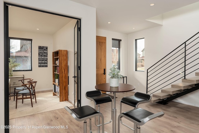 dining room featuring recessed lighting, plenty of natural light, light wood-style flooring, and stairs