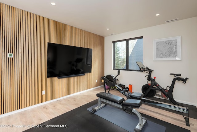 exercise area with recessed lighting, visible vents, baseboards, and wood finished floors