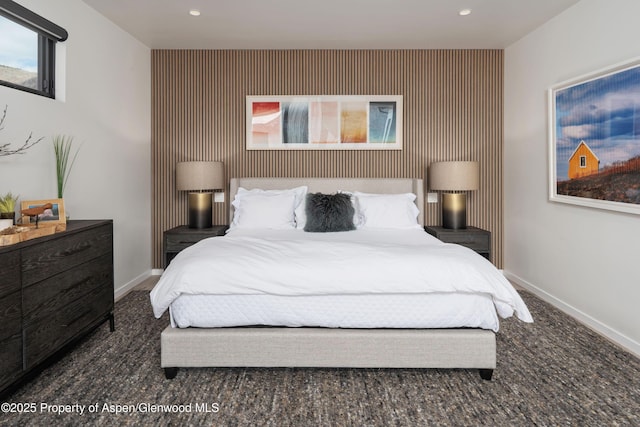 carpeted bedroom featuring recessed lighting, baseboards, and an accent wall