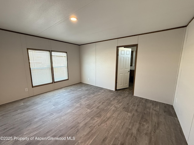 unfurnished room featuring a textured ceiling and dark wood-type flooring