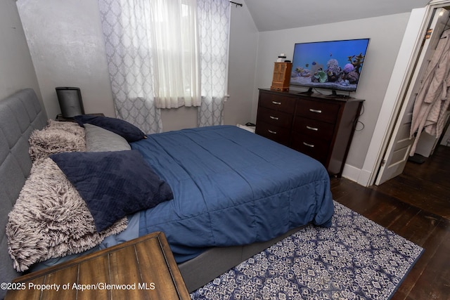 bedroom featuring dark hardwood / wood-style flooring and vaulted ceiling