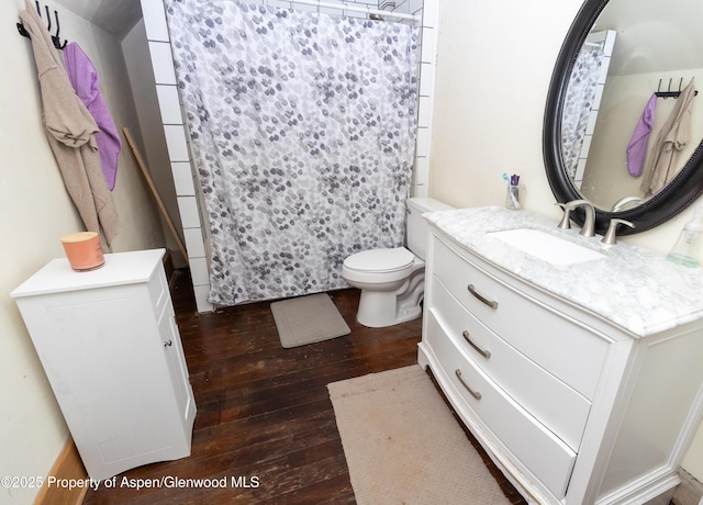 bathroom with wood-type flooring, toilet, vanity, and a shower with curtain