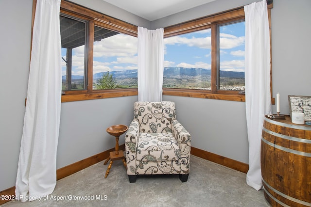 living area with a mountain view, concrete floors, and a healthy amount of sunlight