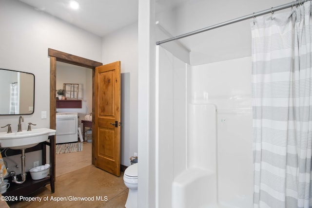 bathroom with sink, walk in shower, tile patterned flooring, washer / clothes dryer, and toilet