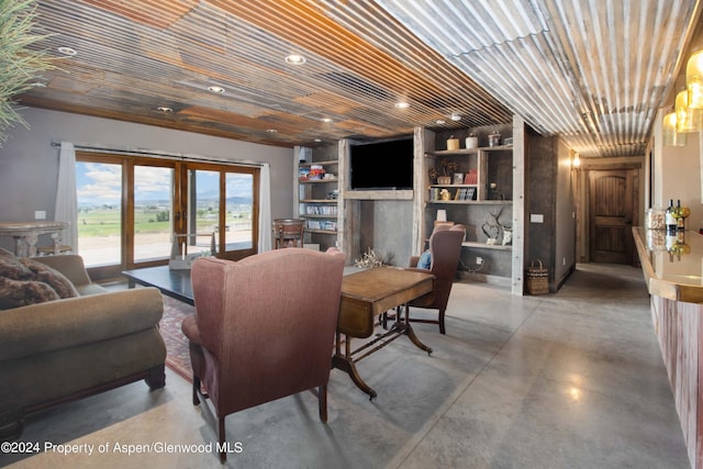 living room featuring french doors, built in features, a fireplace, concrete flooring, and wood ceiling