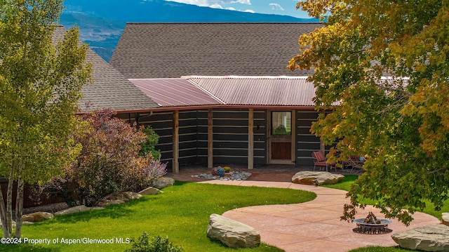 back of property with a yard and a patio area