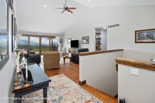 living room featuring ceiling fan, light wood-type flooring, and high vaulted ceiling