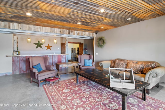 living room featuring concrete flooring and wood ceiling