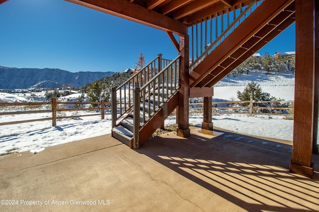 snow covered patio featuring a mountain view