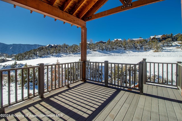 snow covered deck featuring a mountain view