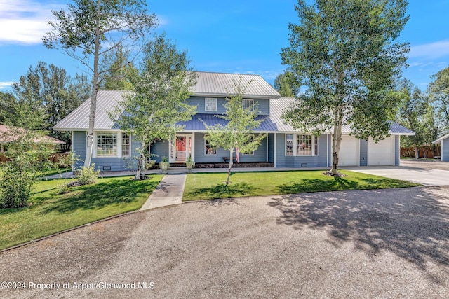 view of front of home with a front yard and a garage