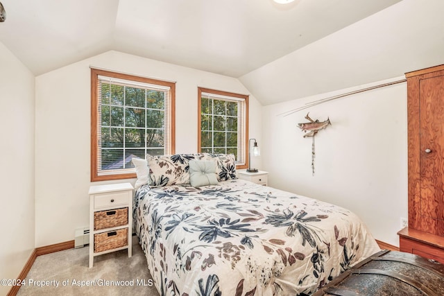 carpeted bedroom featuring a baseboard heating unit and vaulted ceiling