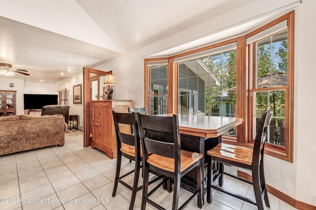 dining space with light tile patterned floors, ceiling fan, and lofted ceiling