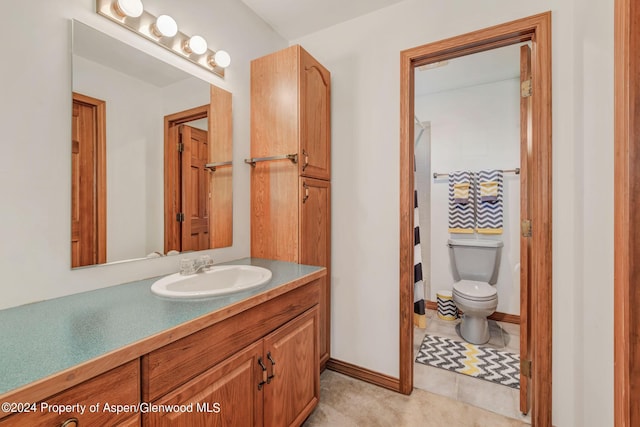 bathroom with tile patterned flooring, vanity, and toilet