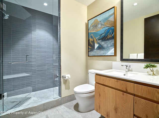 bathroom with tile patterned floors, a shower with door, vanity, and toilet