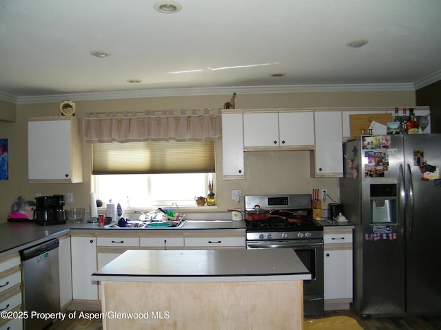 1558 E 12th St, Rifle, CO 81650 - kitchen with appliances with stainless steel finishes, ornamental molding, white cabinets, and a kitchen island