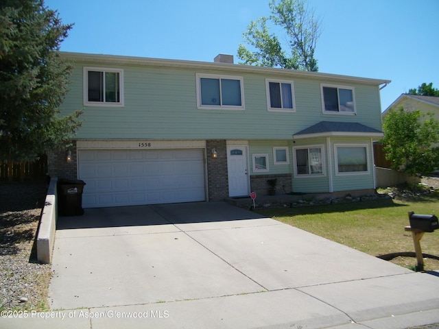 1558 E 12th St, Rifle, CO 81650 - view of front of property featuring brick siding, a garage, driveway, and a front lawn