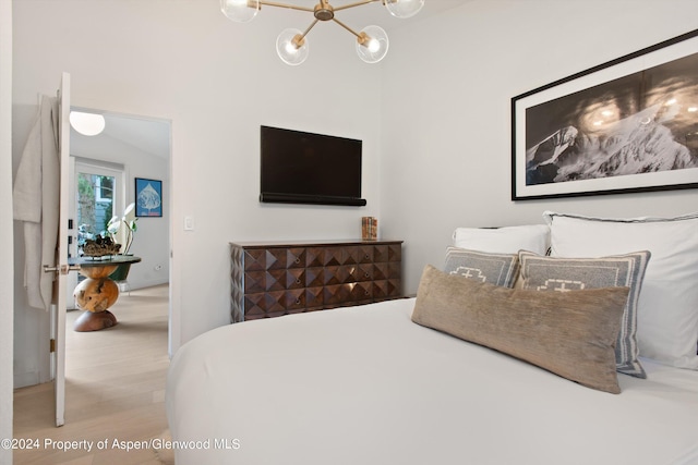 bedroom featuring wood finished floors and a chandelier