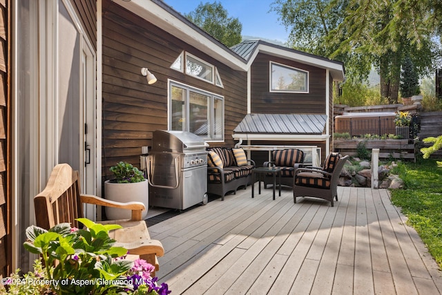 wooden terrace with an outdoor hangout area and area for grilling