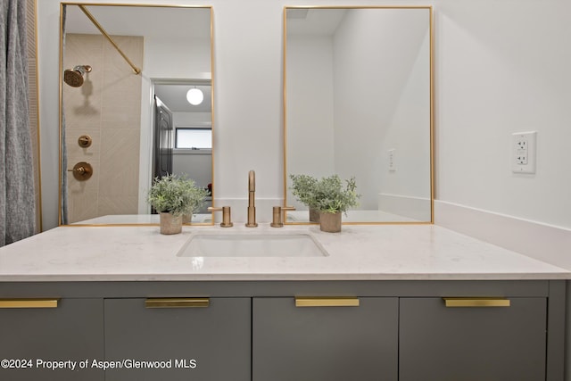 bathroom featuring a tile shower and vanity