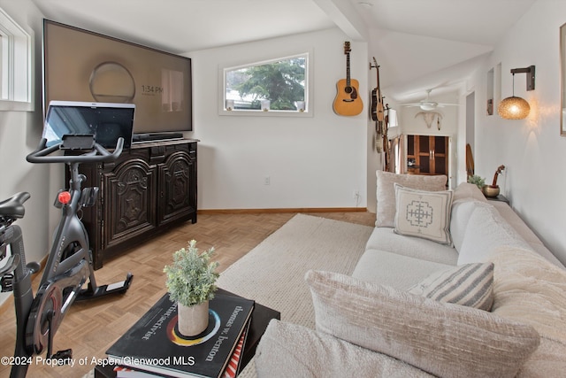 living area with baseboards, lofted ceiling with beams, and ceiling fan