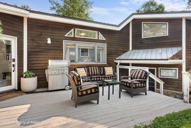 wooden terrace featuring area for grilling and an outdoor hangout area