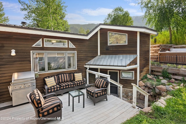 wooden terrace featuring outdoor lounge area and a grill