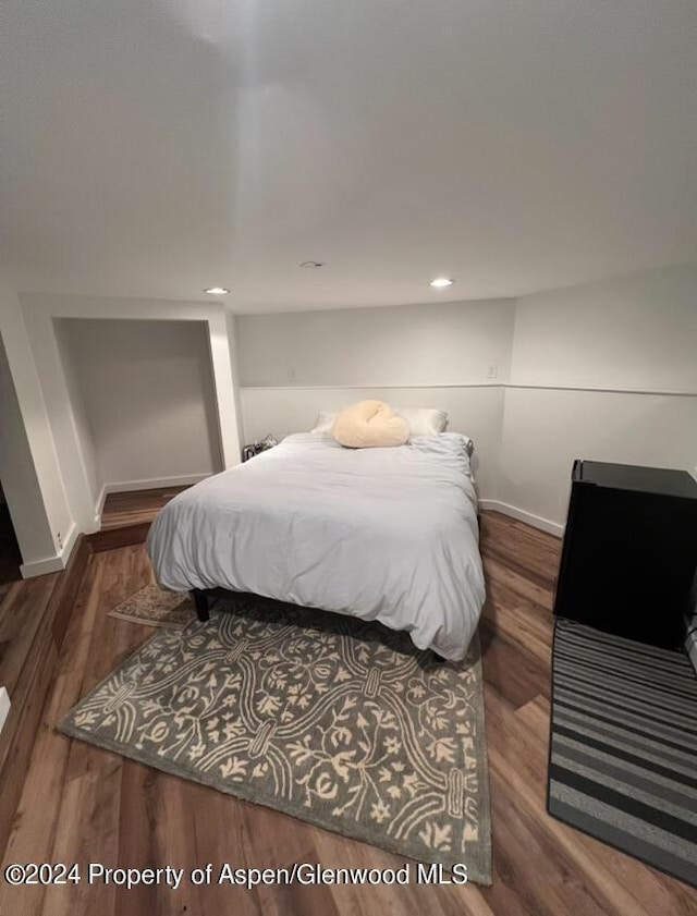 bedroom with baseboards and wood finished floors