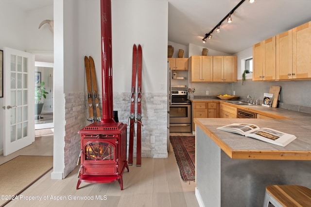 kitchen featuring light brown cabinetry, a sink, rail lighting, electric stove, and lofted ceiling