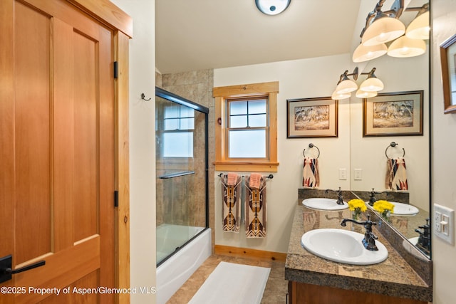 full bath featuring double vanity, combined bath / shower with glass door, and a sink