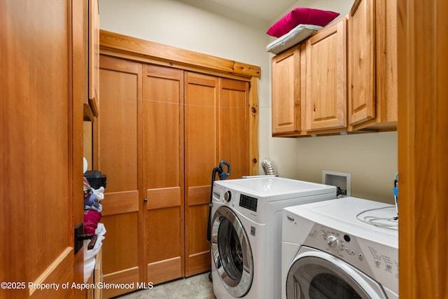 washroom featuring cabinet space and washer and clothes dryer