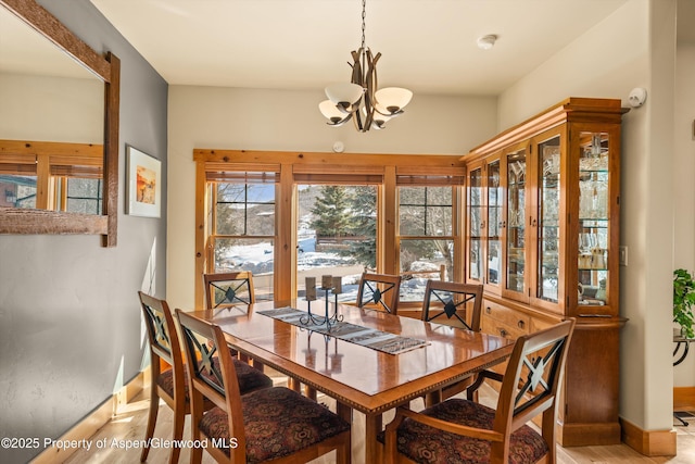 dining room with an inviting chandelier, baseboards, and wood finished floors