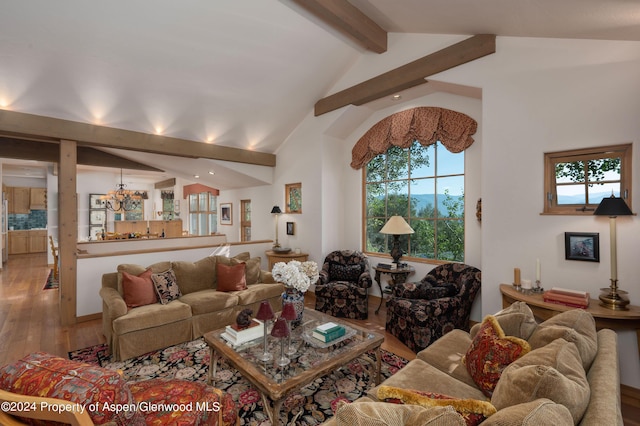 living room with beamed ceiling, a notable chandelier, light wood-type flooring, and high vaulted ceiling