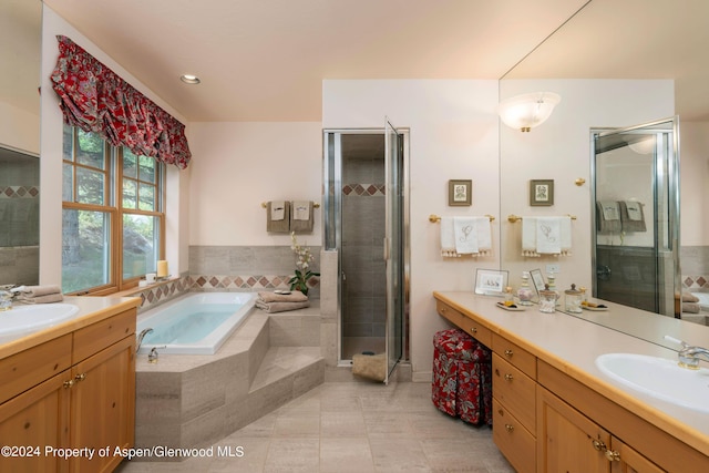 bathroom with tile patterned flooring, vanity, and plus walk in shower