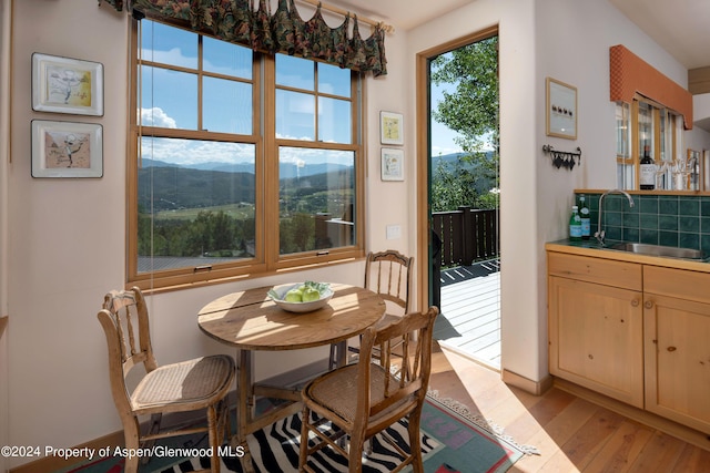 dining room featuring a mountain view, light hardwood / wood-style flooring, and sink