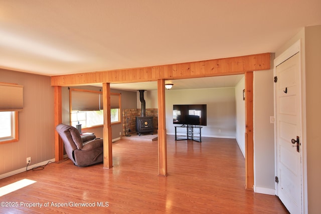 58590 Pe 3/10 Rd, Collbran, CO 81624 - living room featuring a wood stove, light wood-style flooring, and baseboards
