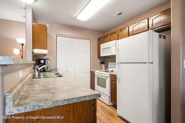 18 Angelica Cir, Parachute, CO 81635 - kitchen with white appliances, a sink, light wood-style flooring, light countertops, and brown cabinets