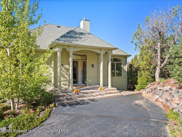 587 Hillcrest Dr, Basalt, CO 81621 - view of front of property featuring a chimney, stucco siding, roof with shingles, and covered porch