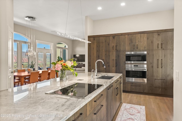 587 Hillcrest Dr, Basalt, CO 81621 - kitchen featuring a sink, black electric stovetop, light stone counters, light wood finished floors, and pendant lighting