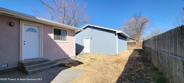 exterior space with stucco siding and fence