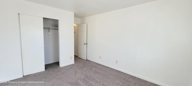 unfurnished bedroom featuring a closet, baseboards, and carpet floors