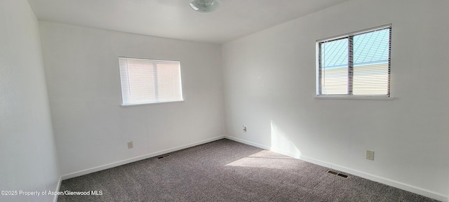 empty room with visible vents, carpet floors, and baseboards