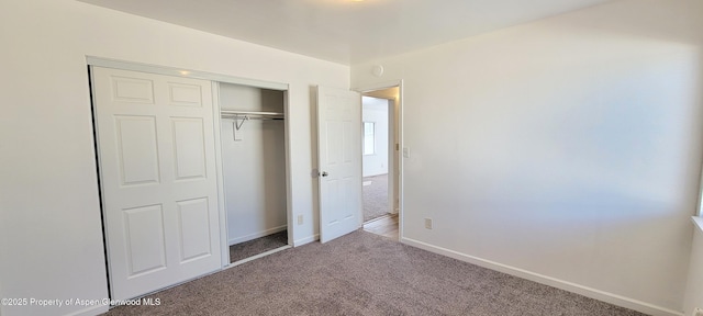 unfurnished bedroom featuring a closet, baseboards, and carpet