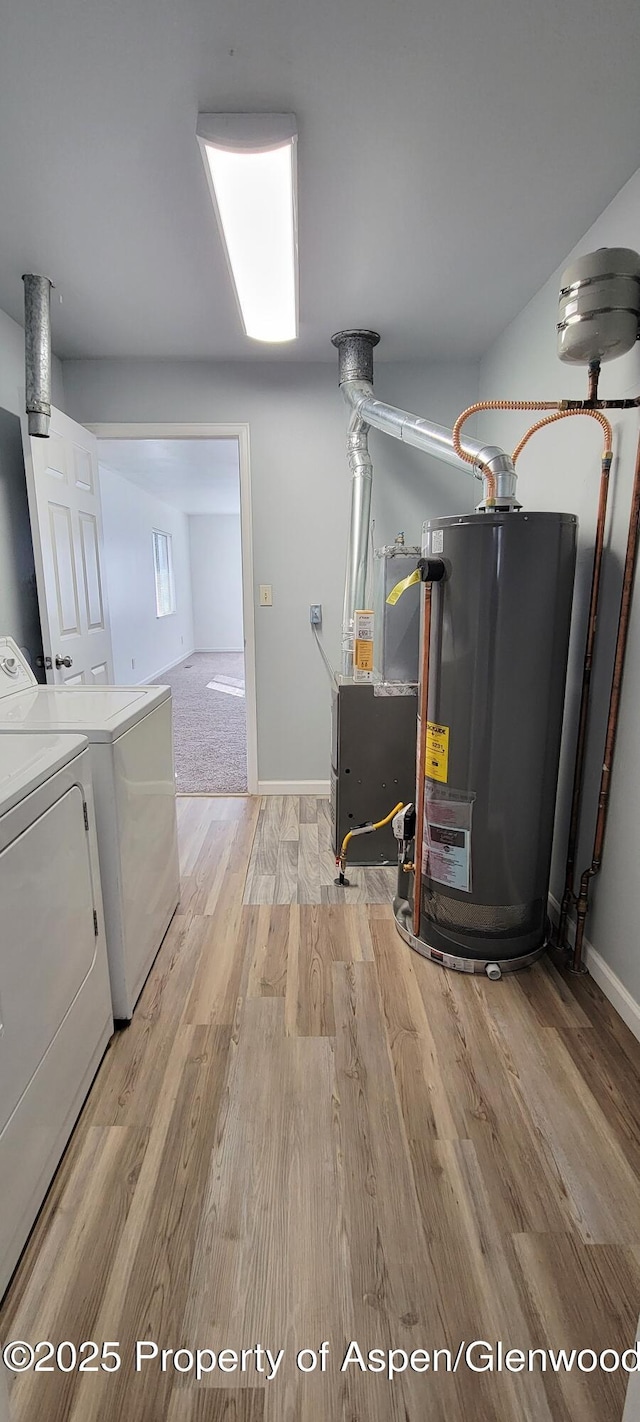 laundry area featuring light wood-style flooring, washer and dryer, water heater, baseboards, and laundry area