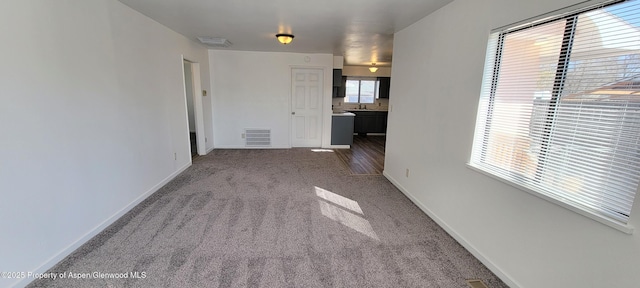 carpeted empty room featuring visible vents and baseboards