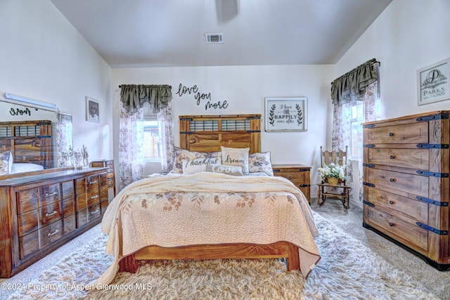 bedroom featuring light carpet and vaulted ceiling