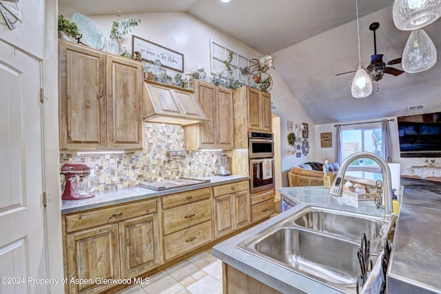 kitchen featuring sink, stovetop, vaulted ceiling, decorative backsplash, and custom exhaust hood